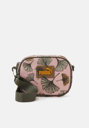 Sac bandoulière rose ornée d'un motif floral, avec quincaillerie marron portant le logo et une bandoulière réglable en olive. Texture lisse, forme rectangulaire.