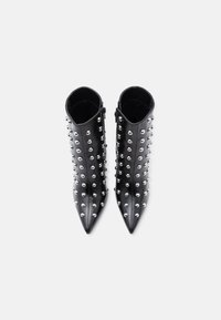 Čierne kožené členkové čižmy s ostrými špičkami, zdobené striebornými cvočkami na vonkajších plochách a so zipsom na jednej strane.