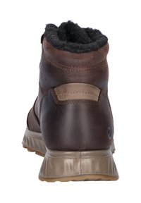 Bruine leren winterlaars met zwarte fleece voering, beige zool en gestikte details, gezien vanaf de achterkant.