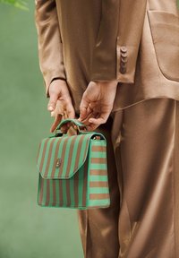 Green and brown striped handbag with a structured shape, textured finish, and a top handle. Gold hardware detail on the front flap.