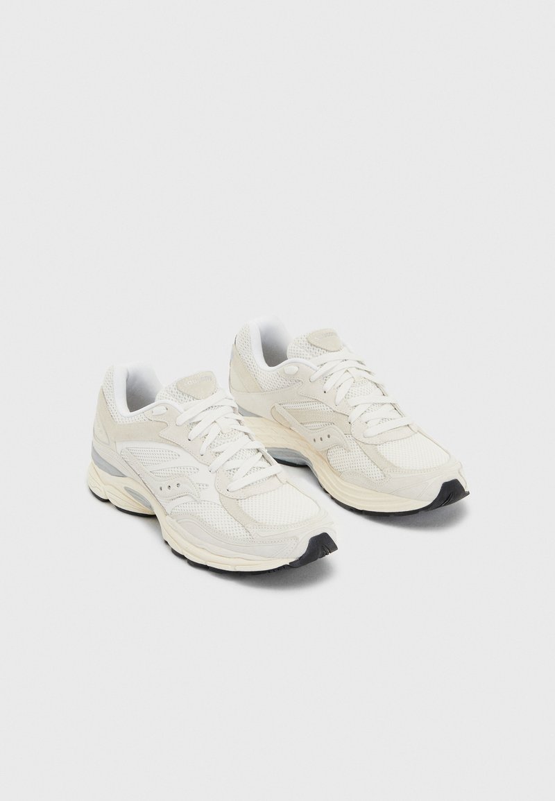 Scarpe da ginnastica bianche con tomaia in rete, punta rinforzata, suola ammortizzata e sottili accenti grigi sui lati e nel tallone. Design con lacci.