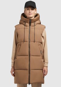 Gilet rembourré marron, sans manches, avec un col montant et une capuche réglable. Dispose d'une fermeture éclair à l'avant et de deux poches latérales. Tissu léger.