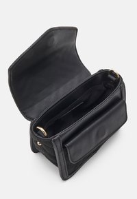 Svart läderhandväska med ett öppet lock, inre fack och en texturerad yta. Har detaljer i guld och en strömlinjeformad design.