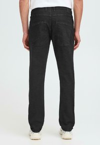 Črne jeans hlače s ravnim krojem, petimi žepi in gladko teksturo; pas z zanke za pas; subtilno šivanje na zadnjem žepu.