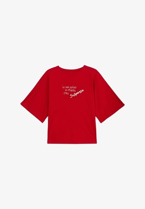 Camiseta roja de gran tamaño con mangas cortas y texto en italiano en blanco que dice "io non arrivo in ritardo creo Suspense" en el centro frontal.