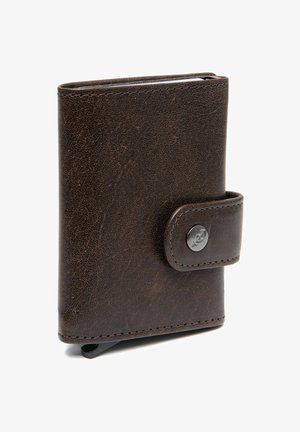 Bruine leren portemonnee met een gestructureerde afwerking, voorzien van een drukknoopsluiting en een ronde metalen accent aan de voorkant. Rechthoekige vorm.