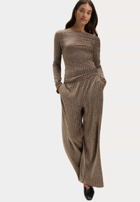 Bruin textuur tweedelig outfit met een lange mouw top en wijde broek; zachte stof met een subtiel patroon.