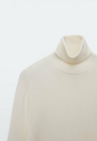 Sweter z golfem w kolorze kremowym, z prążkowanego dzianiny, z długim rękawem, wyeksponowany na jednolitym jasnym tle.