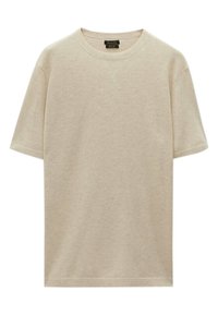 Light beige t-shirt made of textured fabric, featuring a round neckline and short sleeves, with a relaxed fit and minimal stitching details.
