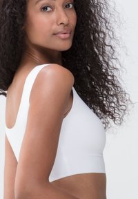 Hvid stræk crop top med en rund halsudskæring og brede skulderstropper, der har en glat overflade og tætsiddende design.