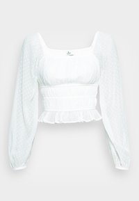 Vit långärmad crop top med genomskinliga prickiga ärmar, samlad midja, fyrkantig halsringning och volangkant.