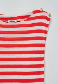 Top de rayas rojas y blancas hecho de algodón, con un escote redondo y dos acentos de botones dorados en el hombro.