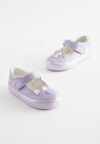 Chaussures Mary Jane synthétiques violettes avec une finition brillante, dotées d'une sangle, d'un design de visage de chat et d'une semelle blanche. Les détails remarquables incluent des oreilles et un gland.