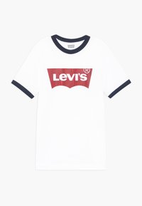 Camiseta blanca con cuello redondo y puños de canalé en azul marino. Presenta un destacado logo rojo de Levi's en el frente en un diseño gráfico.