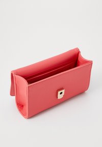 Borsa sintetica rosa con una superficie liscia, progettata con una serratura quadrata in metallo dorato e una parte superiore aperta che rivela un interno rosso.