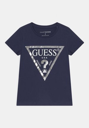 Mørkeblå T-shirt med korte ærmer med sølv trekantslogo og tekst "GUESS U.S.A. Washed Jeans" på fronten. Størrelse 2, rund halsudskæring.