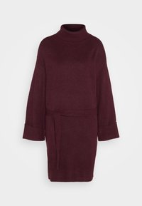 Burgundy stickad klänning med hög krage, vida ärmar och knytmidja. Mjuk textur med avslappnad passform, som slutar ovanför knäet.