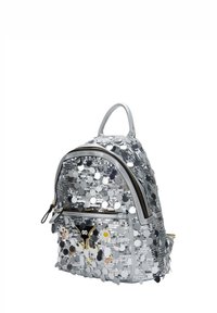 Ezüst flitteres hátizsák kerek formával, dupla cipzárral és egy kis felső fogantyúval. Az elején díszítő foltok találhatók, amelyek további részletességet adnak.