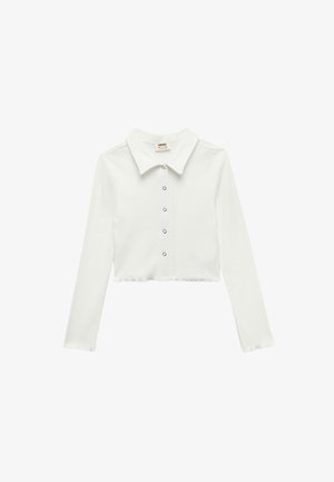 Weißes, kurz geschnittenes Langarmshirt mit Kragen und vorderer Knopfleiste. Hergestellt aus einem strukturierten, weichen Material. Verfügt über einen geraden Saum.