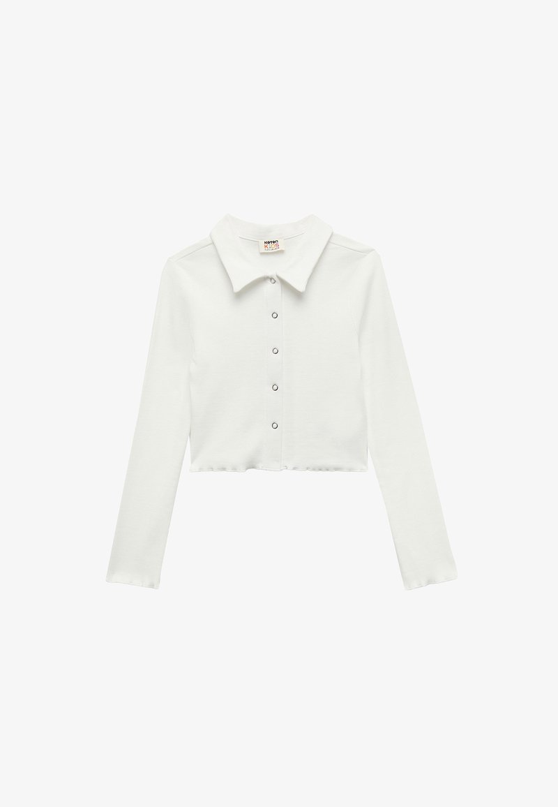 Weißes, kurz geschnittenes Langarmshirt mit Kragen und vorderer Knopfleiste. Hergestellt aus einem strukturierten, weichen Material. Verfügt über einen geraden Saum.