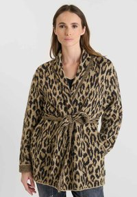 Cárdigan de estampado de leopardo con cuello de chal, cintura ceñida y mangas largas. Fabricado en un tejido suave y texturizado en tonos marrón y negro.