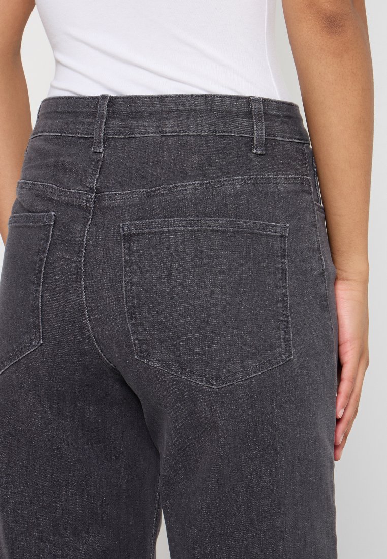 Pantaloni in denim grigio scuro con vita a media altezza, tasche posteriori standard e una texture liscia. Il tessuto sembra leggermente sbiadito.