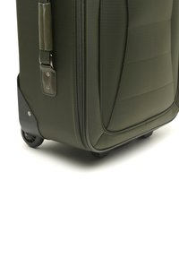 Valigia verde con ruote, realizzata in tessuto testurizzato, con finiture curve e una maniglia laterale. Presenta ruote robuste e una chiusura con zip.