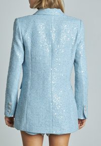 Blazer azzurro chiaro con paillettes, tessuto texturizzato, design a un solo petto e dettagli in bottone argentato sulle maniche.