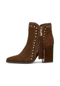 Stivale alla caviglia in suede marrone con punta affusolata, decorato con borchie metalliche, dotato di una cerniera dorata e un dettaglio con nappina sul lato.
