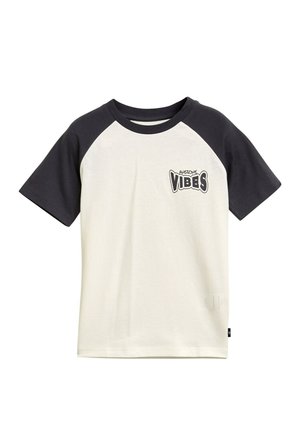 Camiseta de manga corta con cuerpo blanco y mangas raglán oscuras. Presenta un gráfico en negro que dice "AWESOME VIBES". Fabricada en material de algodón suave.