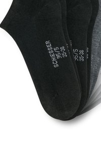 Paquet de trois chaussettes noires et gris foncé à coupe basse, avec la taille et le texte de la marque imprimés sur les semelles.