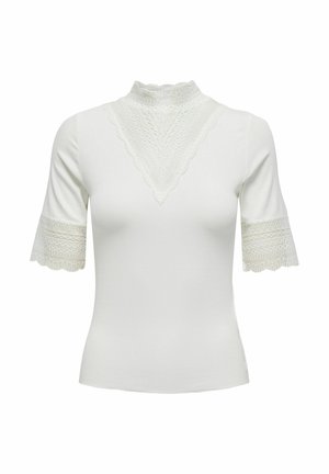 Blouse blanche cintrée à manches courtes avec col montant en dentelle, détail triangulaire en dentelle sur la poitrine et bordure en dentelle aux extrémités des manches.