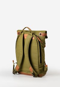 Zaino verde oliva con dettagli in pelle tan, doppie cinghie per le spalle, manico superiore, chiusura arrotolabile e tasca frontale con zip.