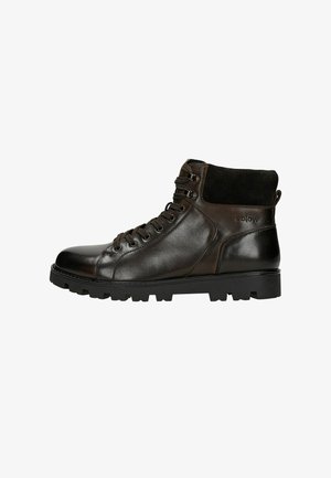 Stivali ankle in pelle marrone con finitura liscia, colletto testurizzato, punta rotonda, lacci frontali e suola in gomma resistente con trazione.