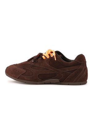 Chaussure de sport en daim marron avec des lacets orange, présentant un design texturé et des découpes incurvées sur les côtés, avec une semelle en caoutchouc flexible.