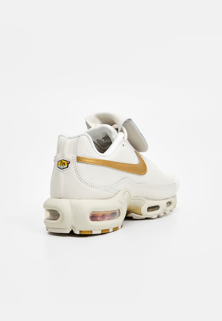 Weiße Sneaker mit goldenen Akzenten, Obermaterial aus Leder, gepolsterte Zwischensohle, transparente Luftkammer und doppelte Klettverschlüsse für sicheren Halt.