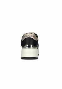 Sneaker nera e beige con una forma arrotondata. Presenta un tallone metallico e un logo sul retro. Tessuto strutturato e dettagli lisci.