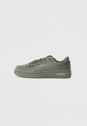 Grüner Leder-Sneaker mit rundem Zehenbereich, strukturiierter Gummisohle, kontrastierenden dunklen Schnürsenkeln und goldenem Markenlogo an der Seite.
