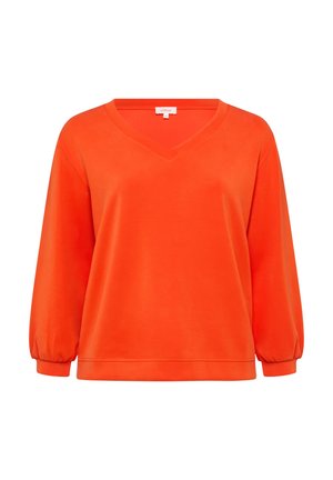 Pull léger à col en V de couleur orange vif, fabriqué en tissu doux. Il présente des manches longues légèrement bouffantes et une coupe décontractée avec une texture lisse.