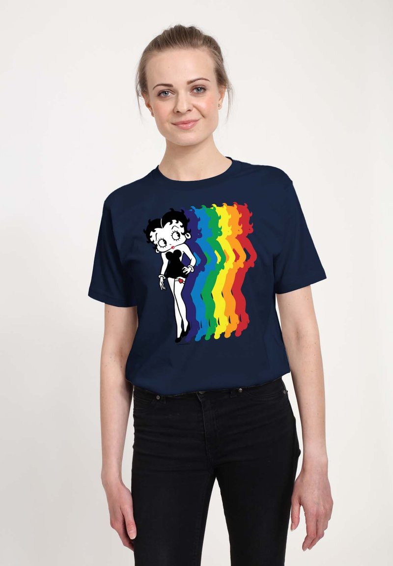 T-shirt blu navy con un personaggio dei cartoni animati in un vestito nero, con un design di silhouette arcobaleno multicolore su un lato. Maniche corte.