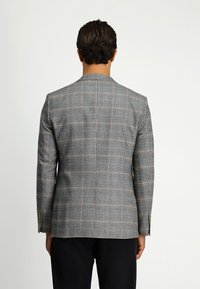 Grijze geruite blazer met een gestructureerde vorm, voorzien van een notch-kraag en gouden knoopaccenten. De achterkant toont een gladde textuur en een getailleerde pasvorm.