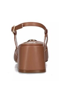 Sandalo con tacco blocco in finta pelle marrone, dotato di una sottile cinghia alla caviglia e un design con ritaglio posteriore. Texture liscia con un tacco resistente e fibbia regolabile.