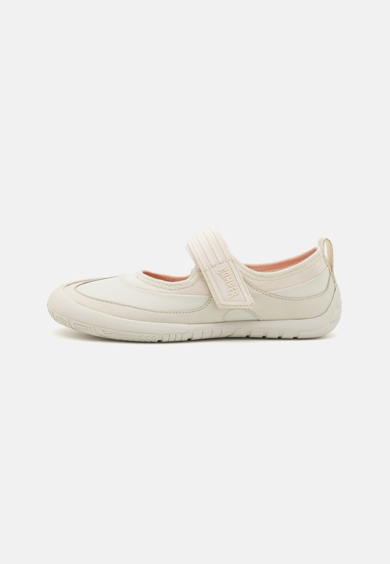 Scarpa slip-on beige con punta arrotondata, cinturino elastico texturizzato, fodera morbida e suola in gomma flessibile con dettagli antiscivolo.