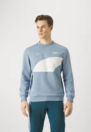Lichtblauwe sweatshirt met witte gebogen accenten, geribde boorden en halslijn; bevat logo-details op de borst. Zachte, casual stof.