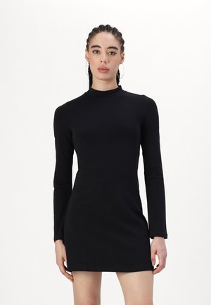Robe mini noire à manches longues avec un col montant. Fabriquée en tissu lisse, elle présente une silhouette ajustée et un design simple.