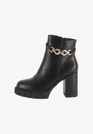 Stivale alla caviglia in finta pelle nera con tacco spesso, suola piatta testurizzata e un accento decorativo in catena dorata alla caviglia.