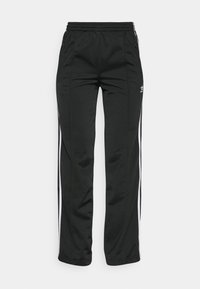 Pantalons de survêtement noirs en polyester lisse. Avec des rayures blanches sur les côtés, une taille élastique et deux poches latérales. Design sportif classique.