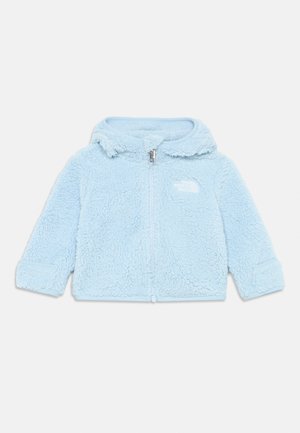 Veste en polaire bleu clair avec fermeture éclair sur le devant, texture extérieure, et capuche. Présente un logo sur la poitrine gauche et des manches à poignets.