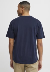 Tricou bleu marin cu mânecă scurtă, cu guler rotund și croială dreaptă. Textură moale, ajustare lejeră și design minimal, fără grafice.
