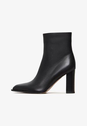 Botine negre până la gleznă, realizate din piele texturată, cu vârf ascuțit și toc gros, cilindric. Finisaj neted cu un design elegant.